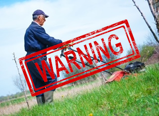 Photograph of man mowing grass with warning stamped on it (the photo, not the grass).